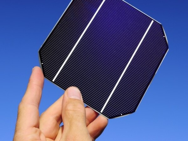 mano sosteniendo una célula solar