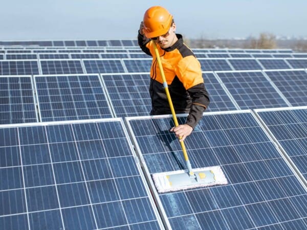 Man cleaning solar panels and photovoltaic systems.